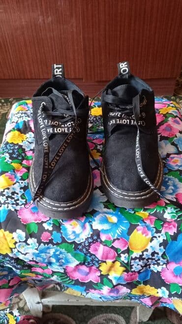 сапоги из натурального меха и кожи: Пара стильных ботильонов черного цвета с декоративными шнурками — 1