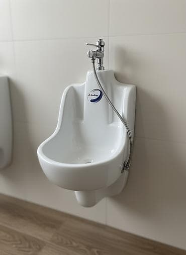 Белый керамический писсуар классического дизайна, предназначенный для