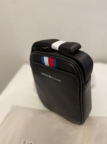 женскую дорожную сумку на колесах: Стильная сумка-мессенджер Tommy Hilfiger черного цвета с регулируемым — 1