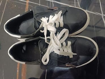 Черные кроссовки кожаные с белыми шнурками и белой подошвой. Модель