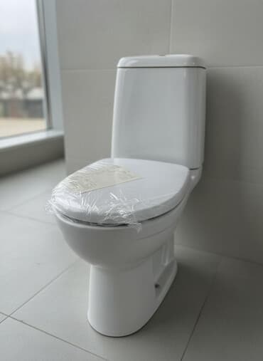 Белый напольный унитаз-компакт с бачком, предназначенный для