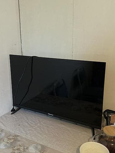 Телевизор Hisense, диагональ около 32–40". Узкие рамки, две устойчивые