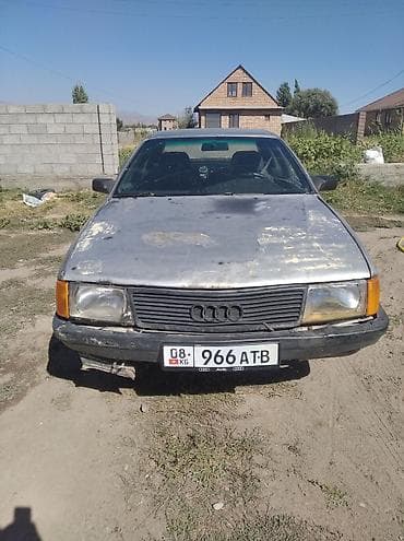 Audi: Седан Audi 100 в сером цвете с характерным дизайном кузова. Автомобиль — 1