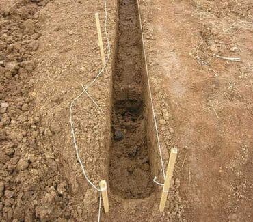 для полива полей: Траншея, выкопанная в земле, с натянутыми направляющими нитями — 1