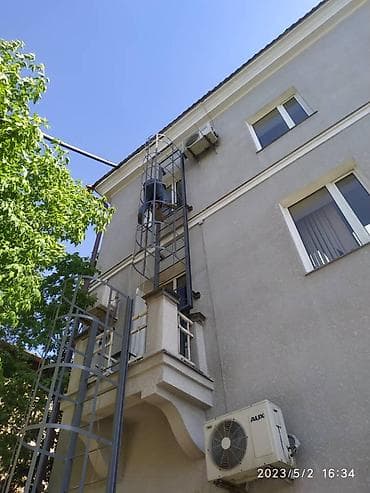 Металлическая пожарная лестница с ограждением (кожухом) для фасада