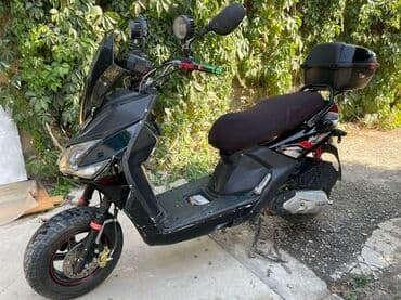 Мотороллер черного цвета, предназначенный для городской езды. Оснащен