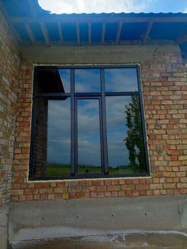 Окно с черной рамой и тремя секциями для остекления. Две секции имеют