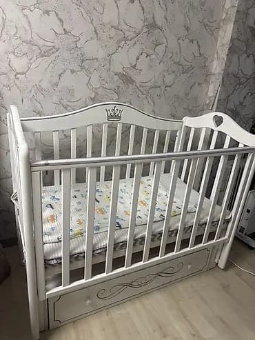 Детская кроватка классического белого цвета с фигурными спинками и