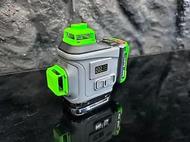 Компактный лазерный уровень серого цвета с яркими зелеными акцентами