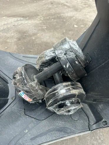 Пара разборных гантелей черного цвета. Диски зафиксированы на грифе с