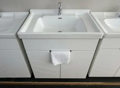 Белая керамическая раковина прямоугольной формы с тумбой. Раковина