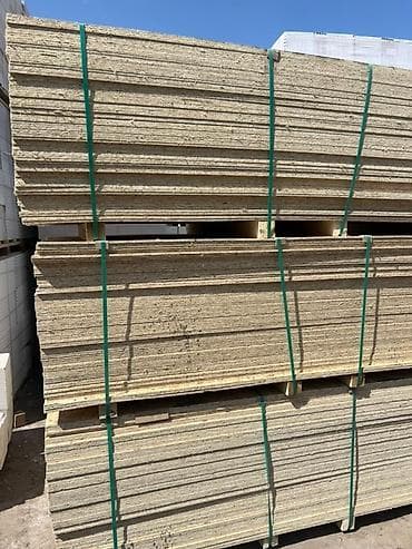 Стопка листов ДСП, скрепленных зелеными лентами, уложенных на at lalafo.kg Стопка листов ДСП, скрепленных зелеными лентами, уложенных на