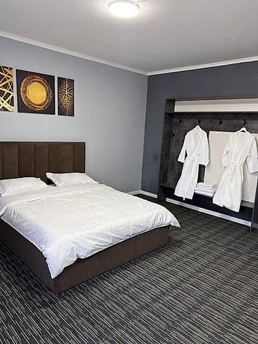 Уютный номер с большой двуспальной кроватью и свежим белым постельным at lalafo.kg Уютный номер с большой двуспальной кроватью и свежим белым постельным